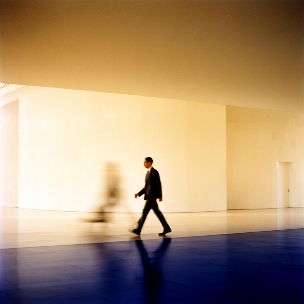 An executive walking through a vast minimalist atrium